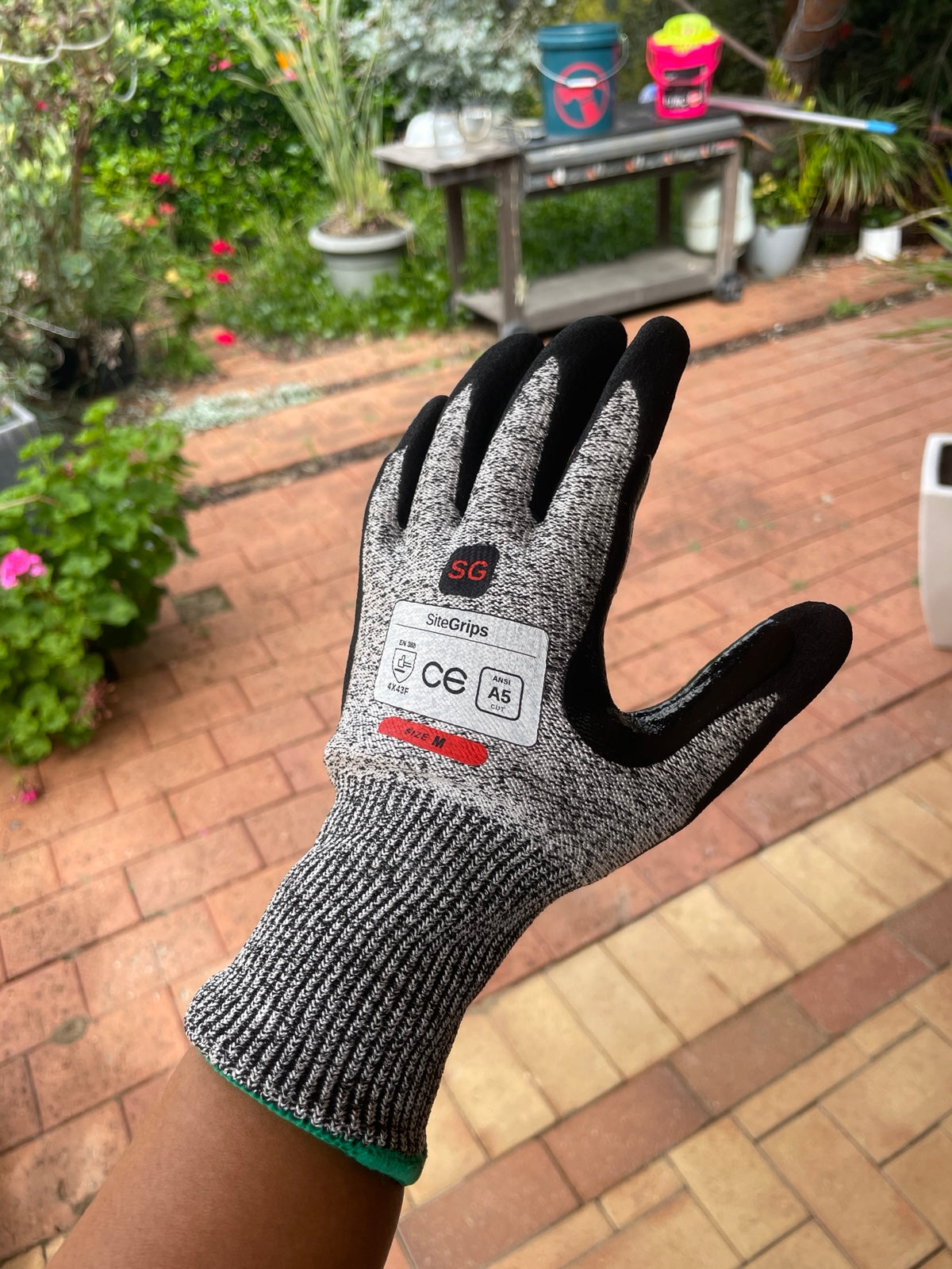 Close view of a SiteGrips cut-resistant glove showing its woven back and safety label.