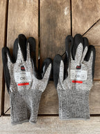 Pair of SiteGrips cut-resistant gloves shown side by side with their safety labels.