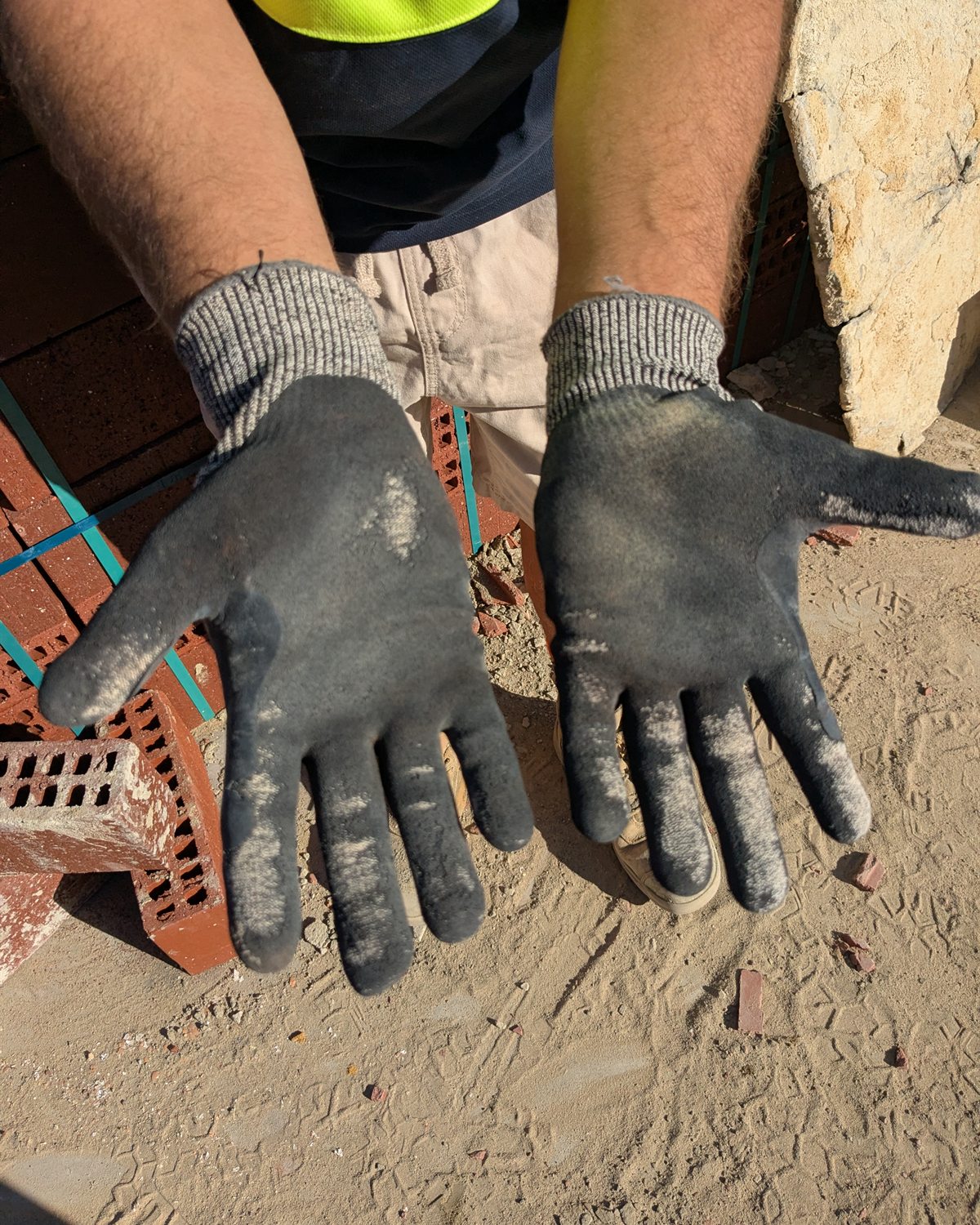 Sitegrips gloves showing dusty palm and finger wear during construction work